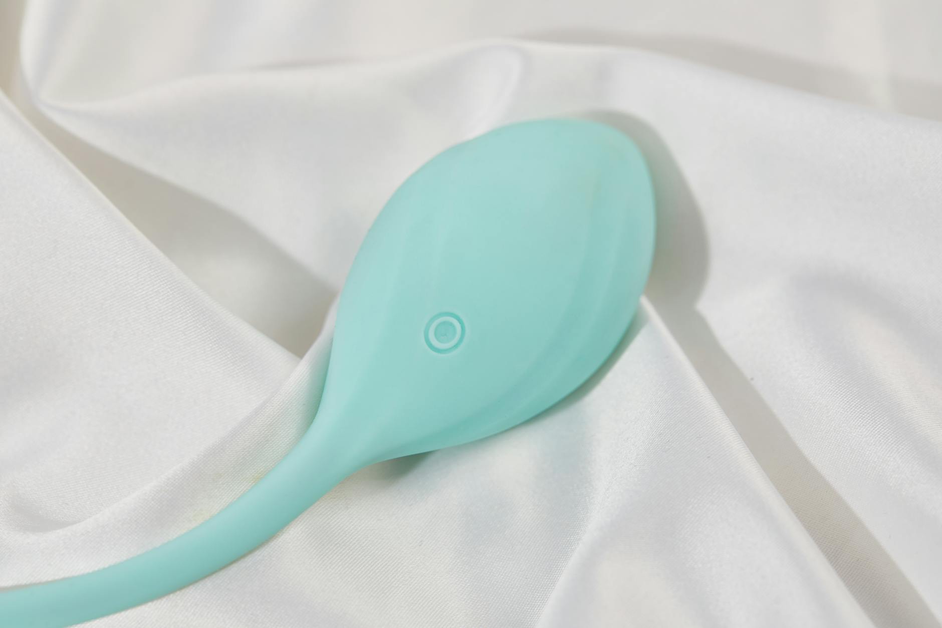 Ein stilvoller Lemon-Vibrator auf glatter weißer Seide