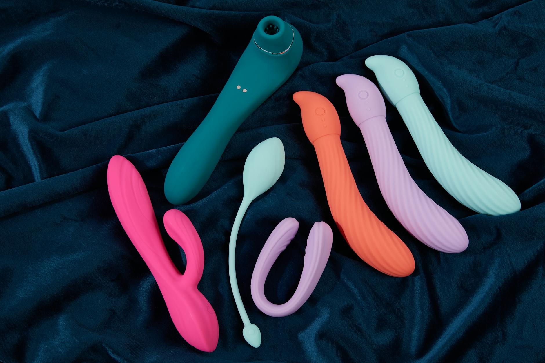 Ein stilvoller türkisfarbener Vibrator auf glatter weißer Seide, perfekt für Lifestyle-Fotografie im Kontext von Intimitätspflege