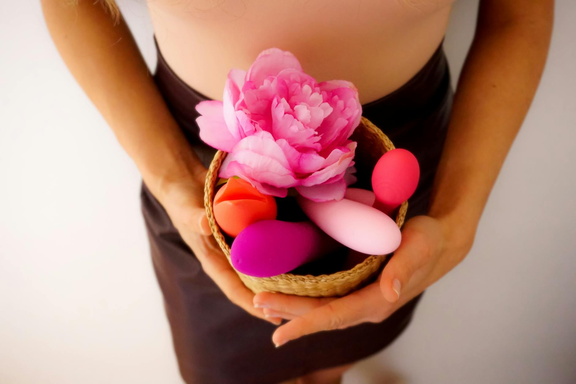 Frau hält einen pinken und blauen Lemon-Vibrator in nachdenklicher Pose
